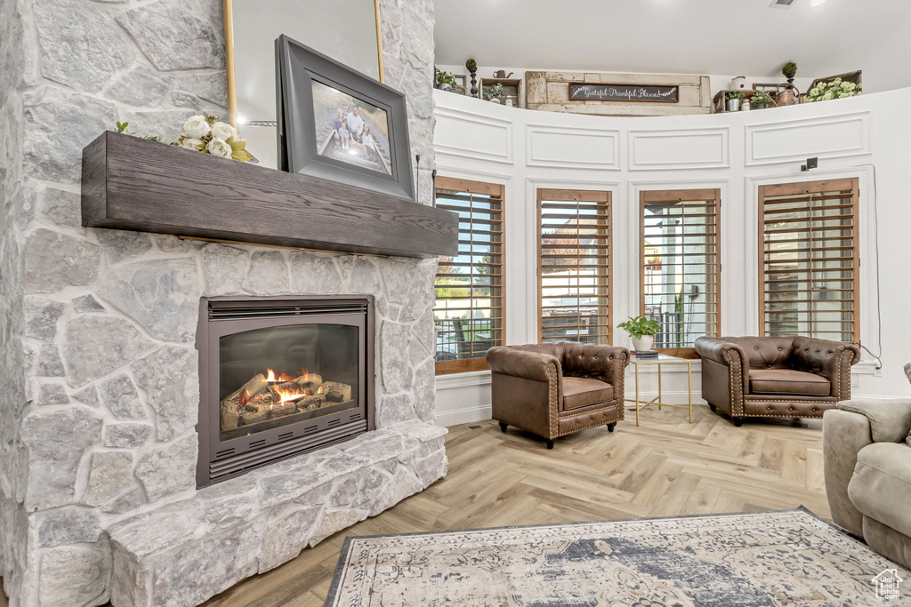 Living room featuring parquet flooring and a stone fireplace