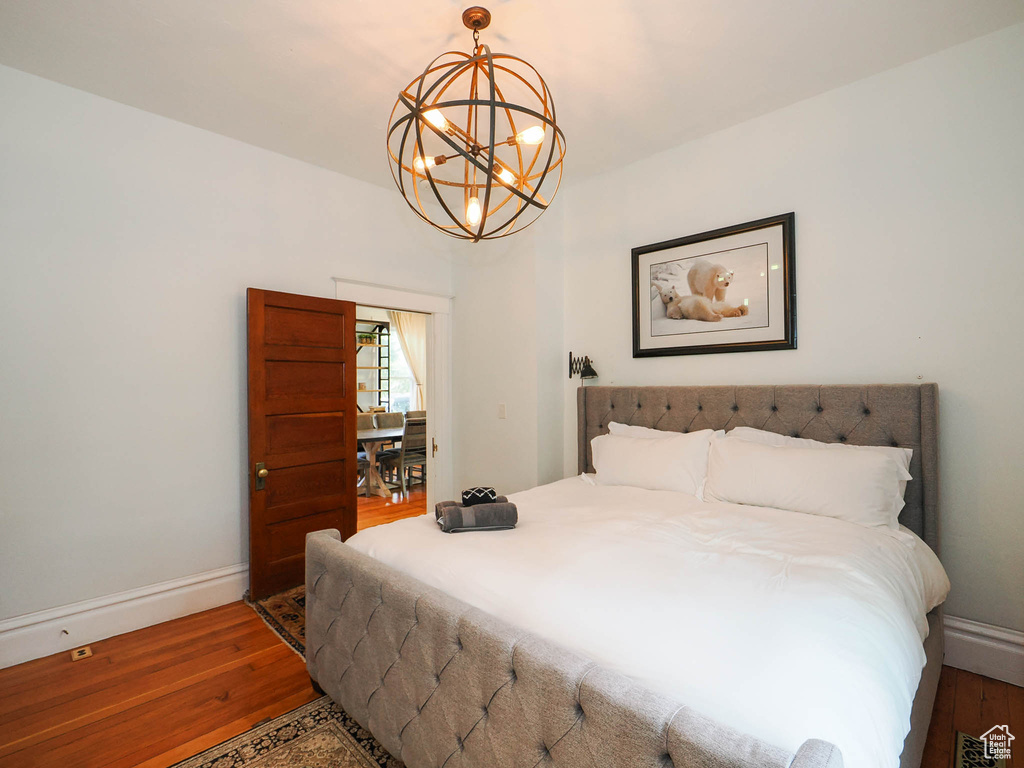 Bedroom featuring hardwood / wood-style flooring and a notable chandelier