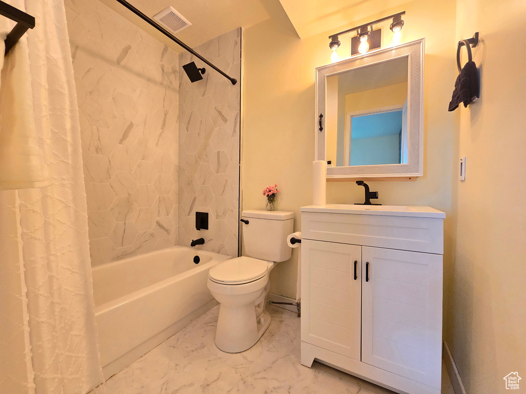 Full bathroom with shower / tub combo, toilet, vanity, and tile flooring