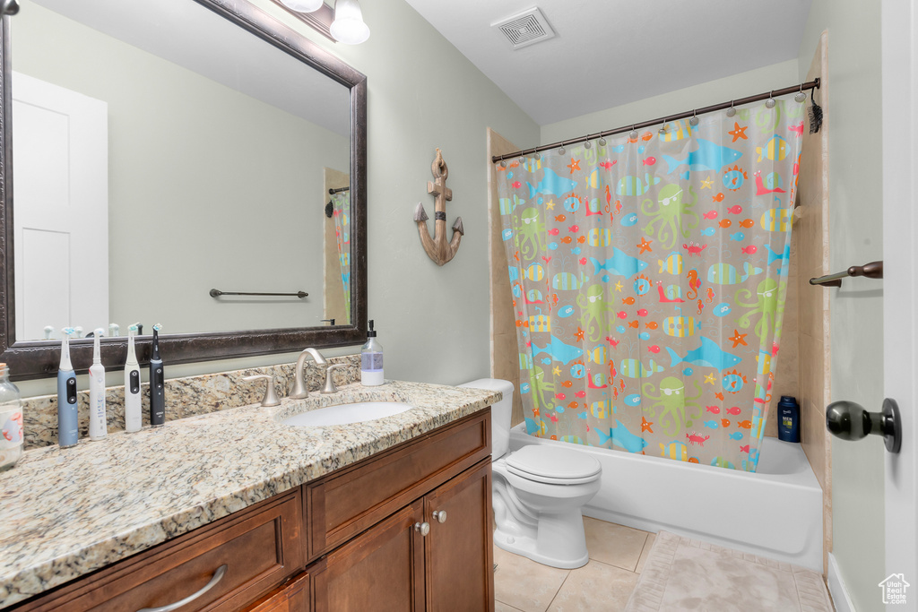 Full bathroom featuring shower / tub combo with curtain, vanity, tile floors, and toilet