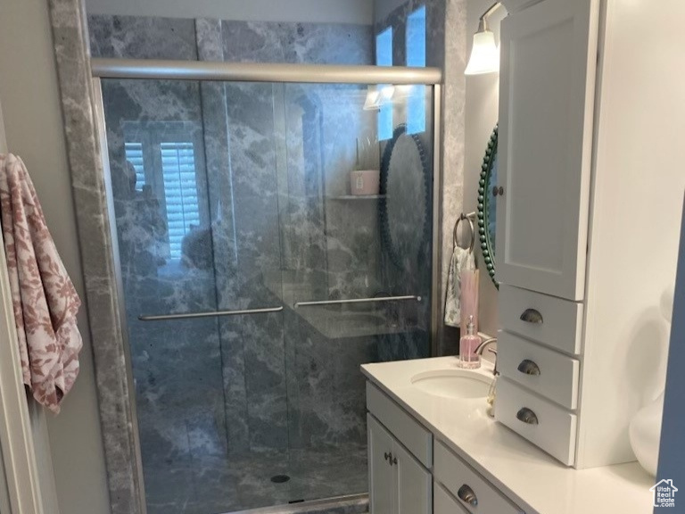 Bathroom with an enclosed shower, tile floors, and double vanity