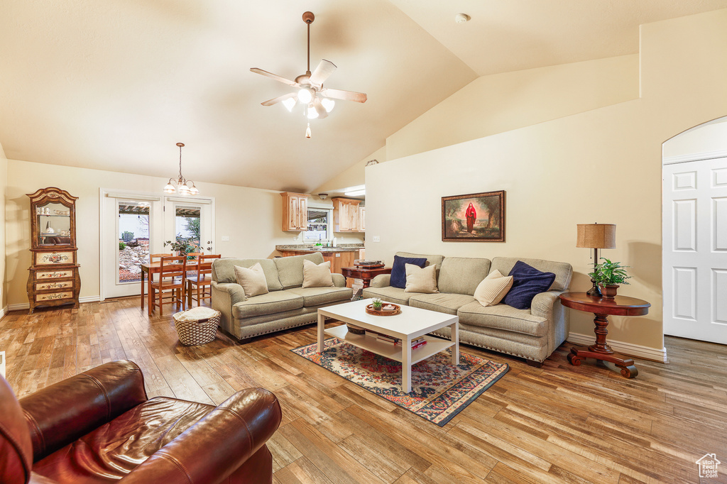 Living room featuring high vaulted ceiling, ceiling fan, and hardwood / wood-style floors