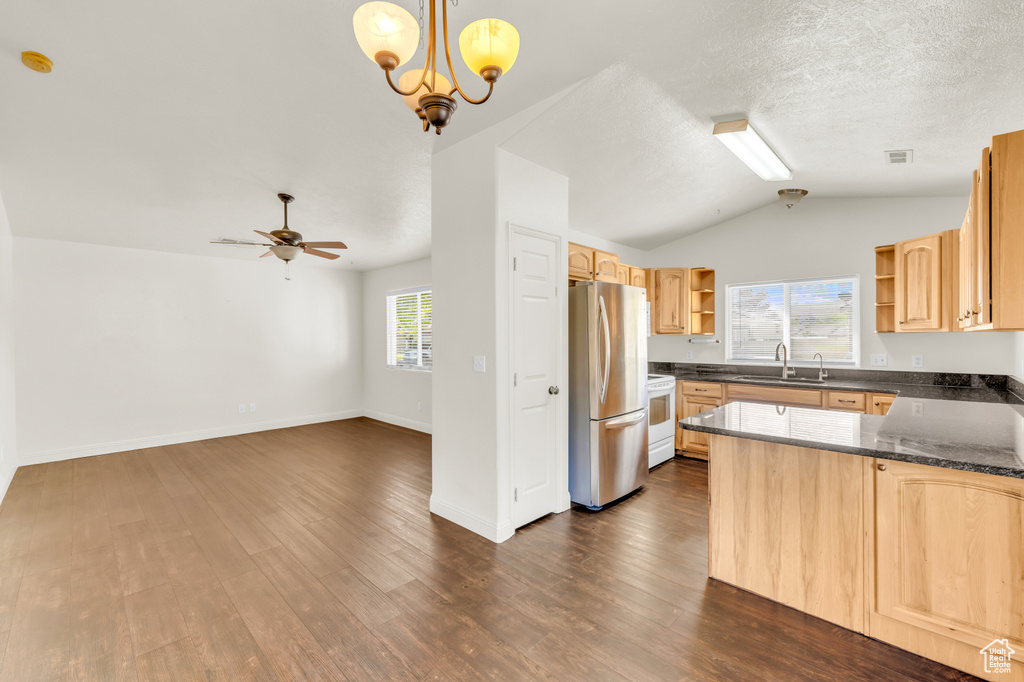 Kitchen with kitchen peninsula, dark hardwood / wood-style flooring, electric stove, stainless steel fridge, and pendant lighting