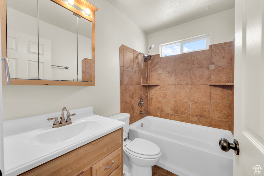 Full bathroom featuring vanity, toilet, tiled shower / bath, and tile flooring