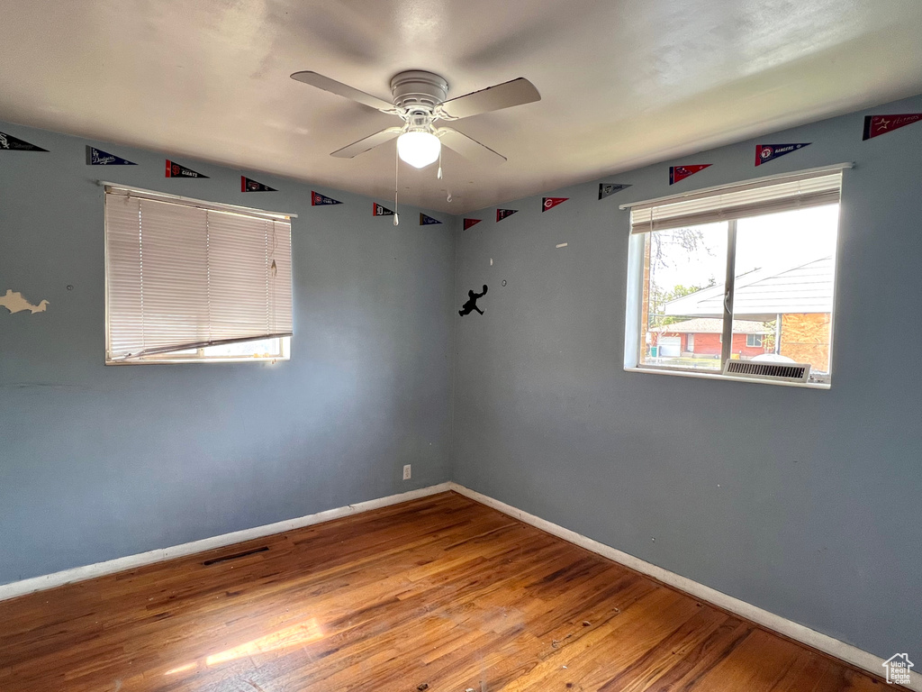 Unfurnished room with ceiling fan and hardwood / wood-style floors
