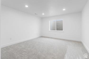 Spare room featuring baseboards, carpet flooring, and recessed lighting