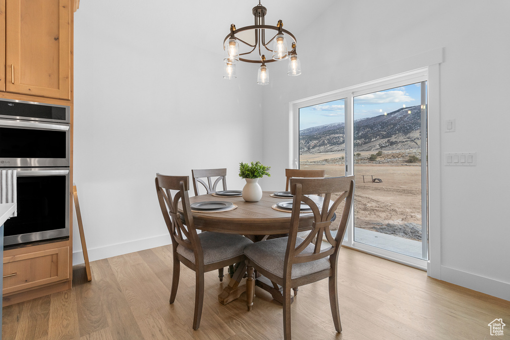 Dining space featuring light wood-style floors, baseboards, and a chandelier