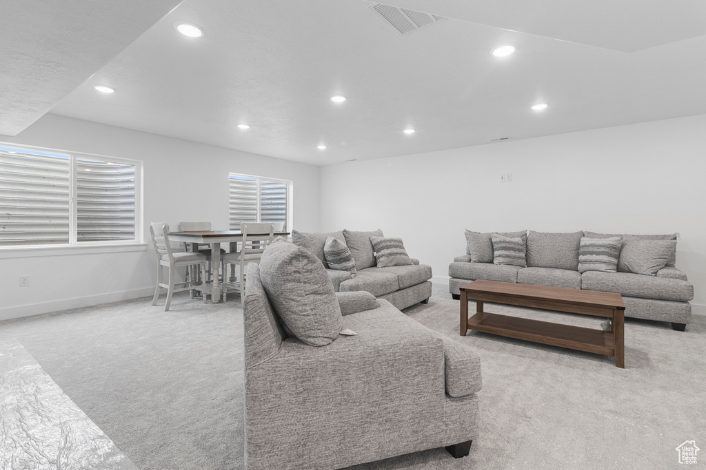 Carpeted living room featuring recessed lighting, visible vents, and baseboards