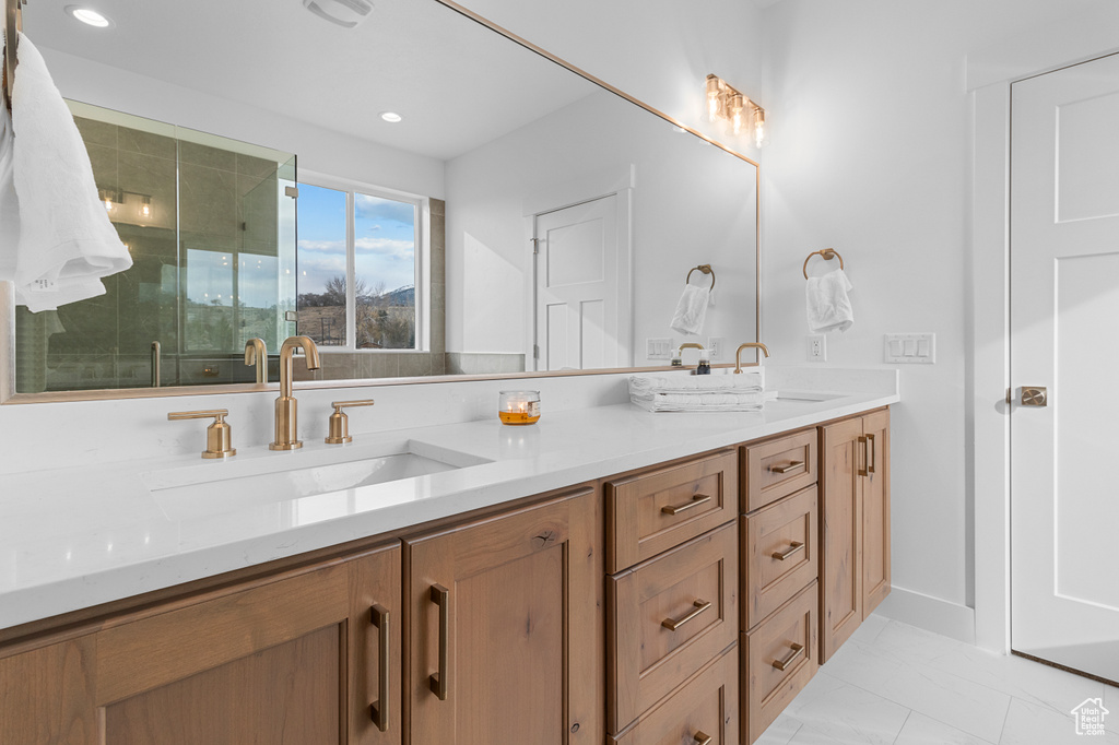 Bathroom featuring double vanity, a shower stall, a sink, and recessed lighting