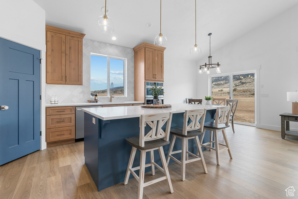 Kitchen with a healthy amount of sunlight, appliances with stainless steel finishes, light countertops, and a center island