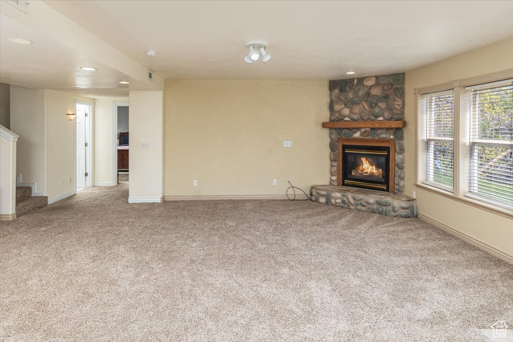 Unfurnished living room with a fireplace and carpet floors