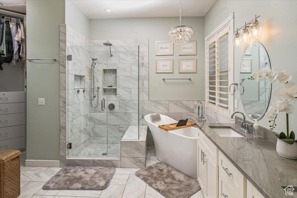 Bathroom with oversized vanity, tile floors, independent shower and bath, and a notable chandelier
