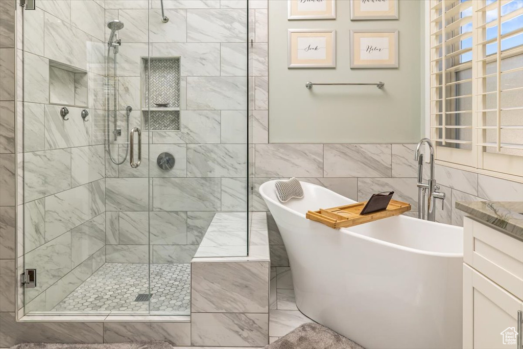 Bathroom with shower with separate bathtub and tile walls