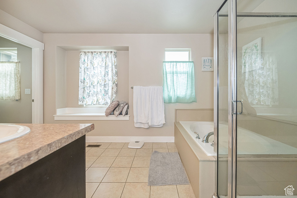 Bathroom with vanity, separate shower and tub, and tile flooring