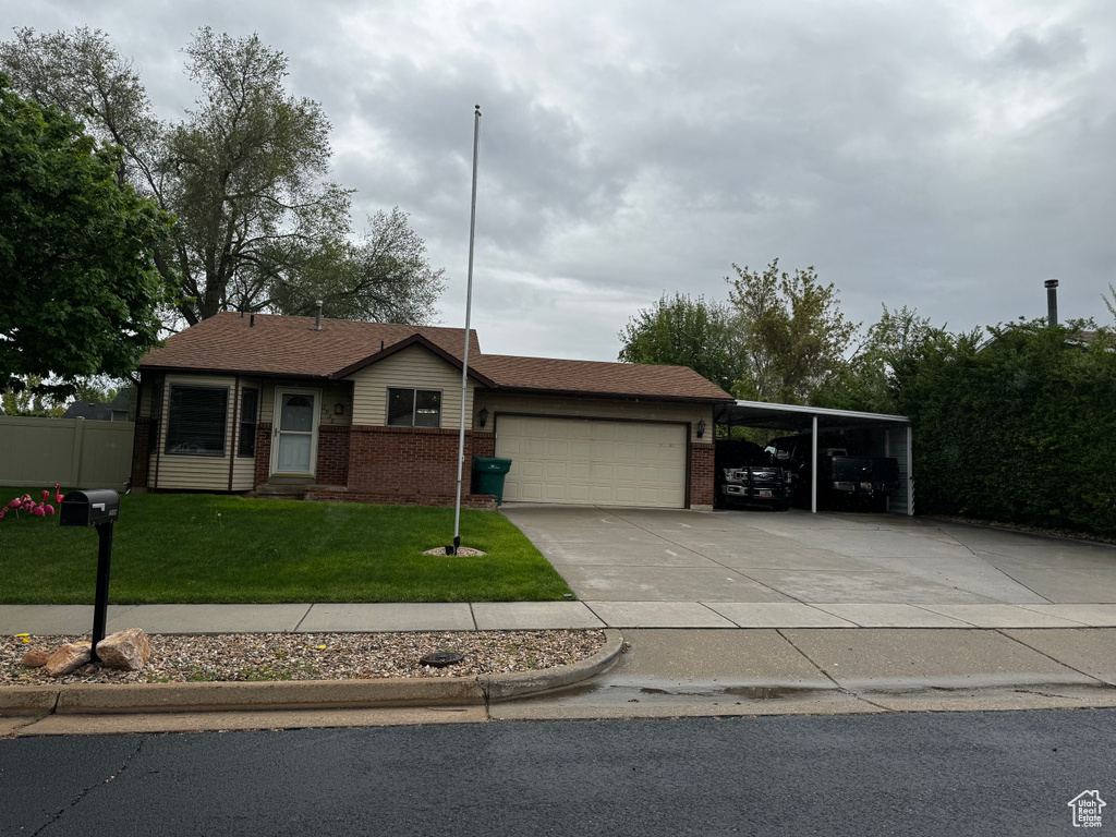 Single story home featuring a garage and a front lawn