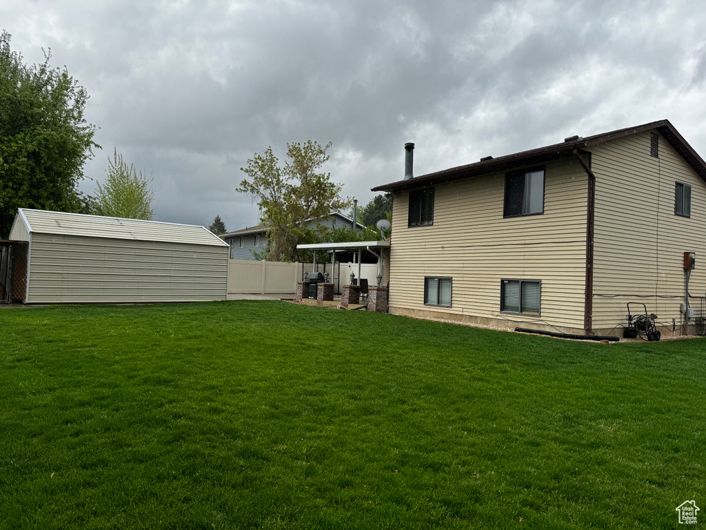 View of yard with a patio and a storage unit