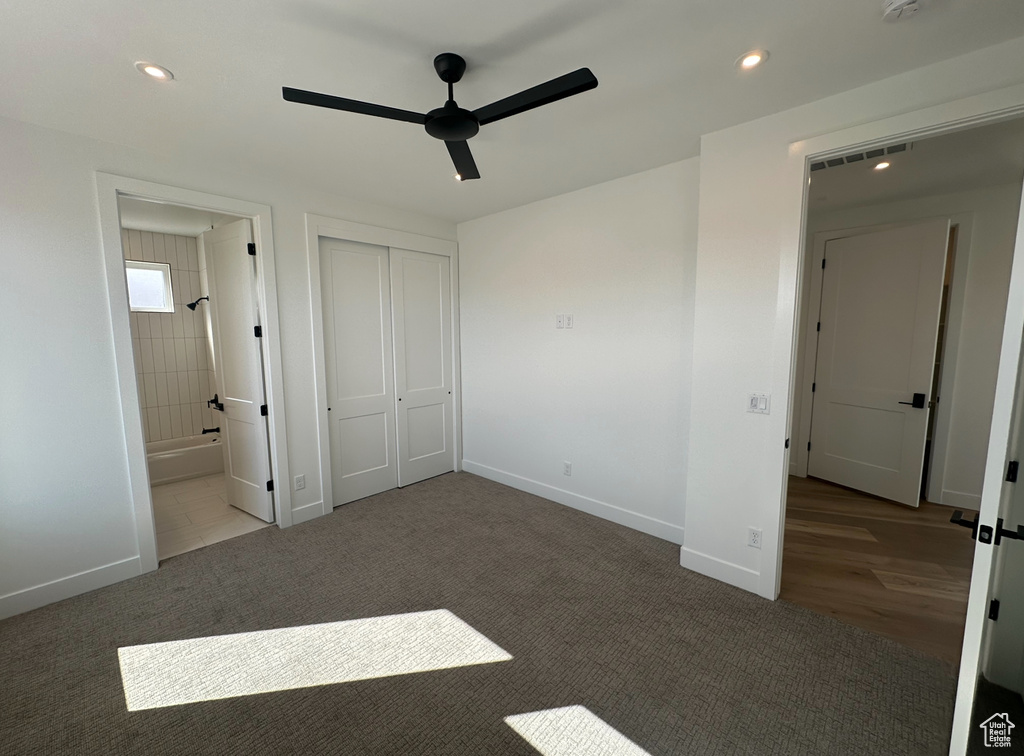 Unfurnished bedroom featuring a closet, ceiling fan, ensuite bath, and hardwood / wood-style flooring