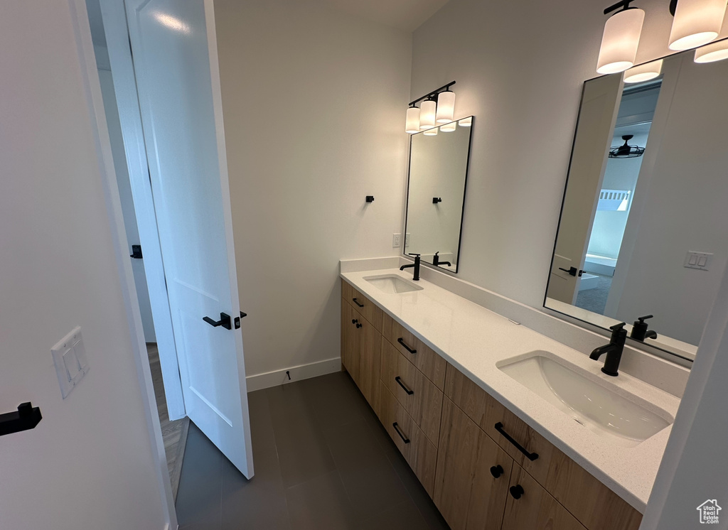 Bathroom featuring tile flooring, oversized vanity, and dual sinks