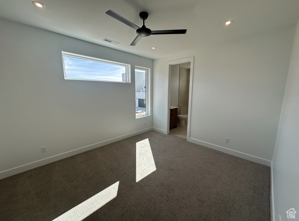 Empty room featuring ceiling fan and carpet floors