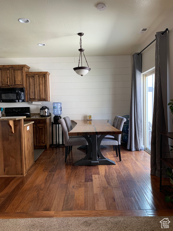 Dining space with dark hardwood / wood-style flooring