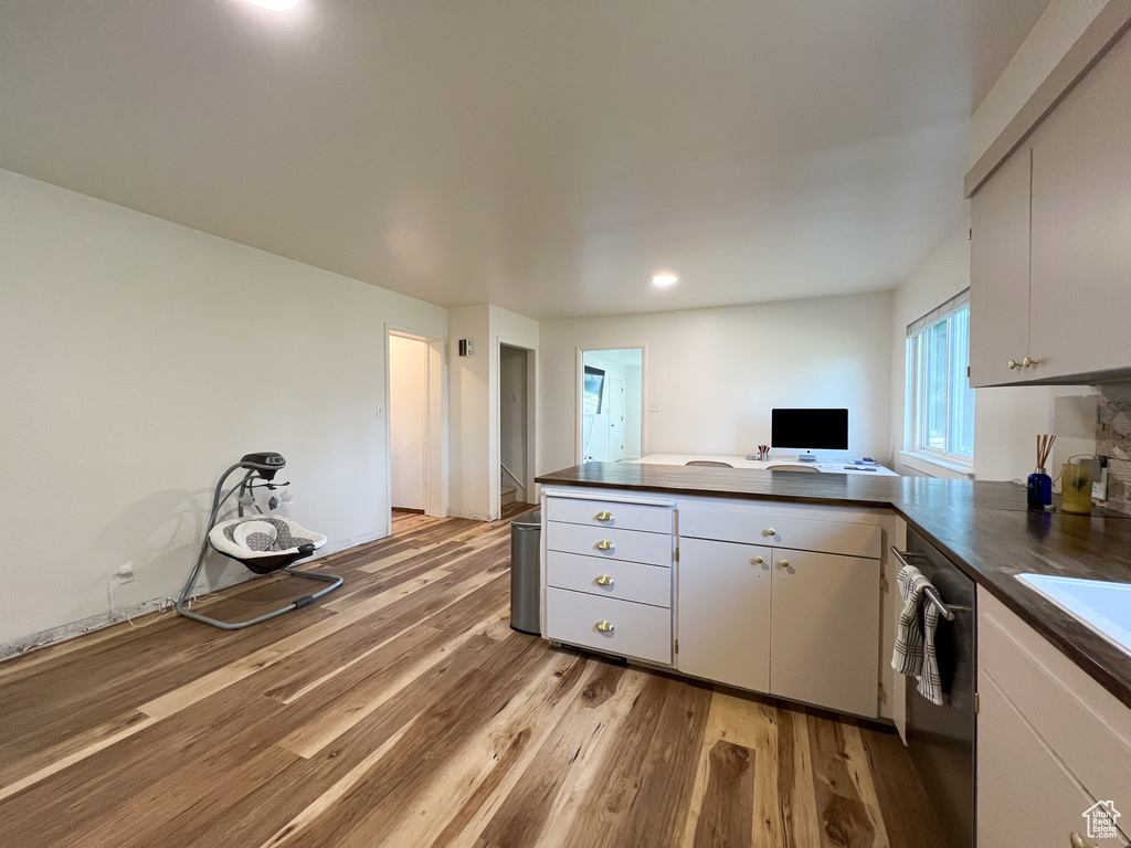 Kitchen featuring light hardwood / wood-style flooring, dishwasher, and white cabinetry