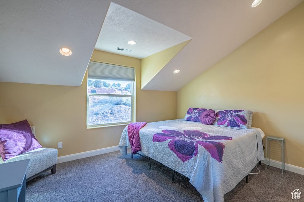 Bedroom with vaulted ceiling and carpet