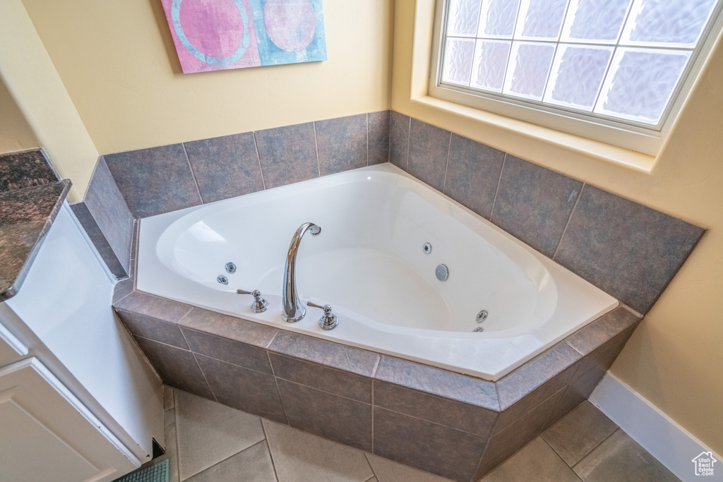 Bathroom featuring vanity, tile floors, and tiled tub