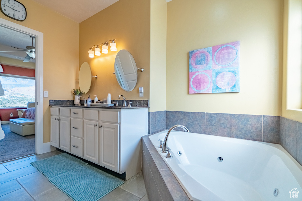 Bathroom featuring dual sinks, tile flooring, ceiling fan, and large vanity