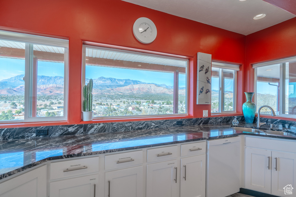 Kitchen with white cabinets, sink, a mountain view, and dishwasher