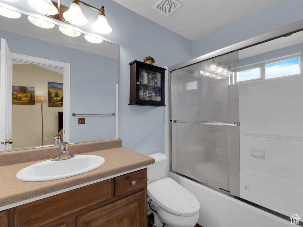 Full bathroom featuring vanity, toilet, and enclosed tub / shower combo
