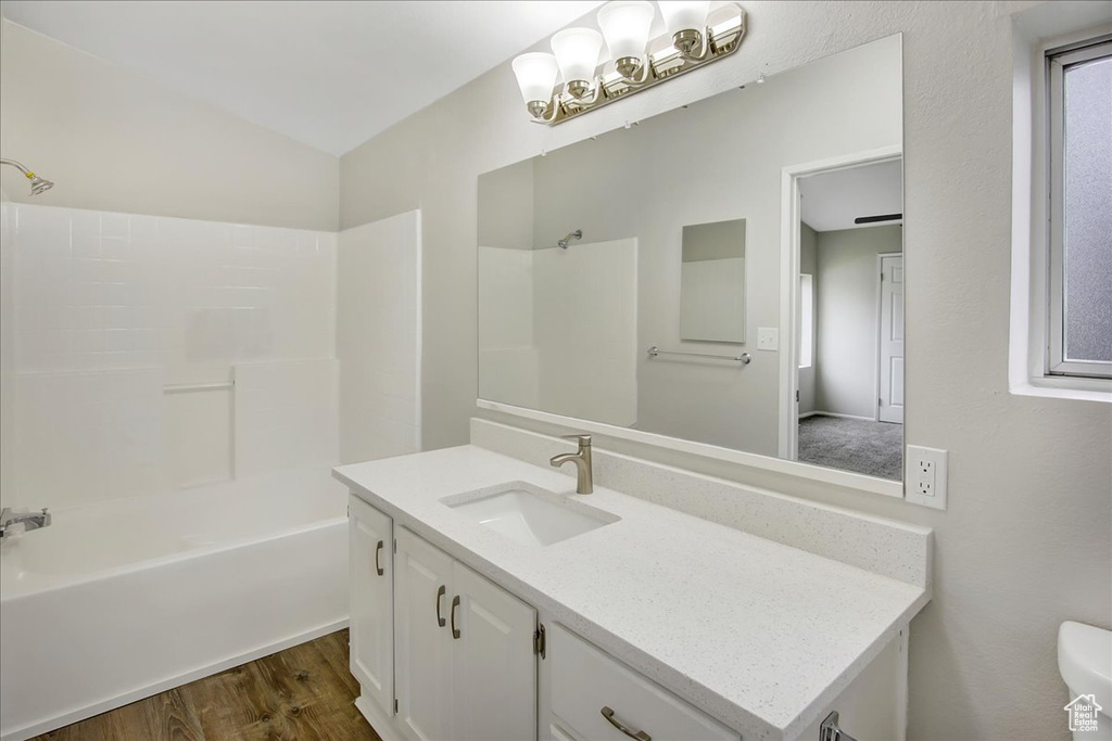 Full bathroom with hardwood / wood-style flooring, tub / shower combination, toilet, and vanity