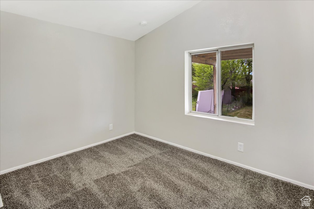 Spare room with vaulted ceiling and carpet floors