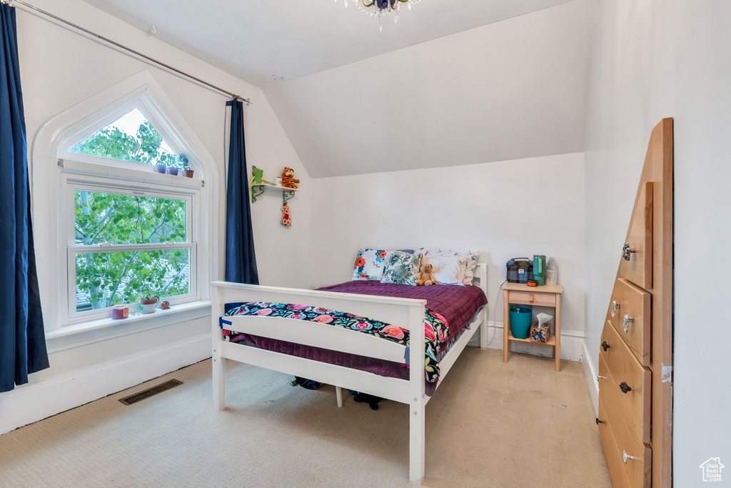 Bedroom with vaulted ceiling and carpet flooring