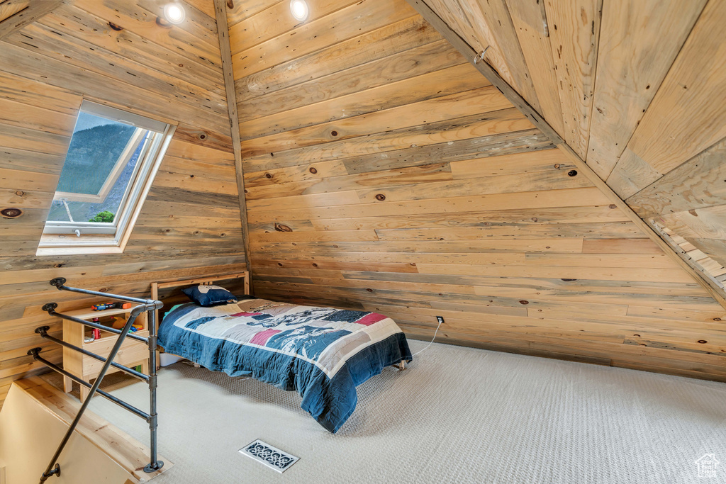 Bedroom featuring wood walls and wooden ceiling