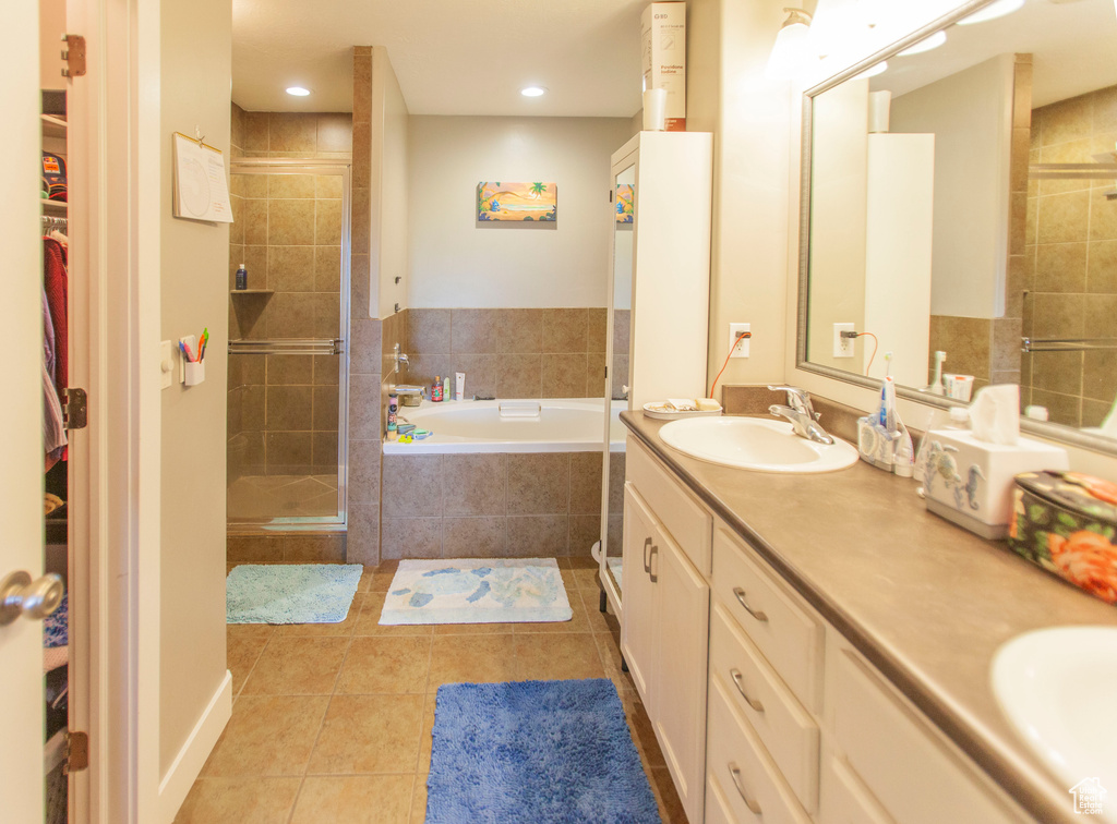 Bathroom with independent shower and bath, tile floors, and dual vanity