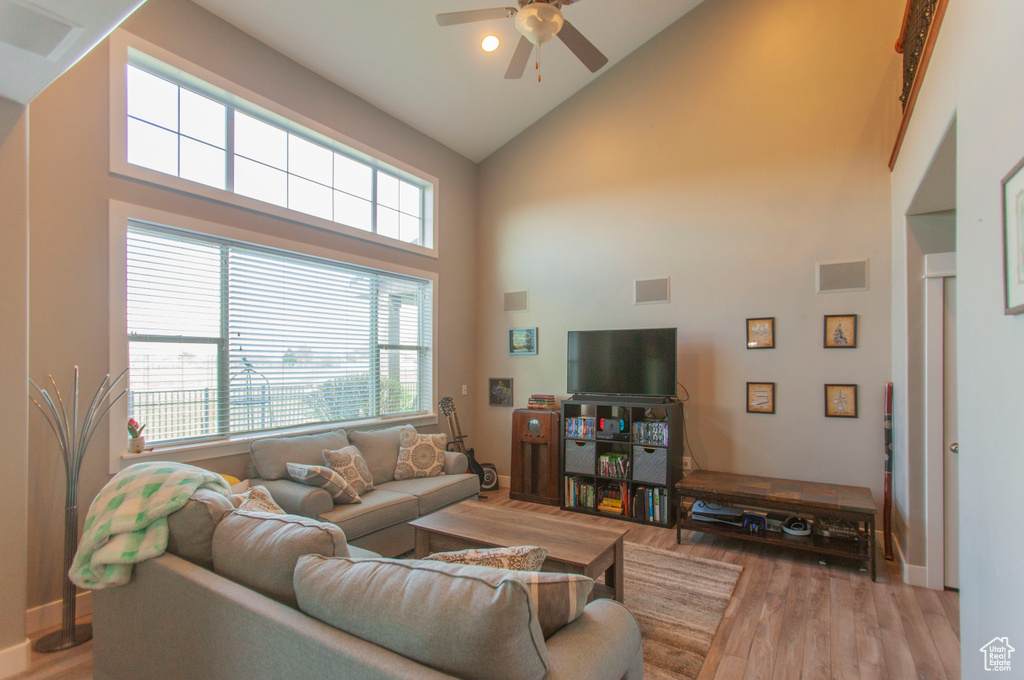Living room featuring ceiling fan, high vaulted ceiling, and hardwood / wood-style floors
