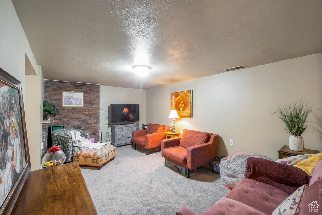Carpeted living room with brick wall