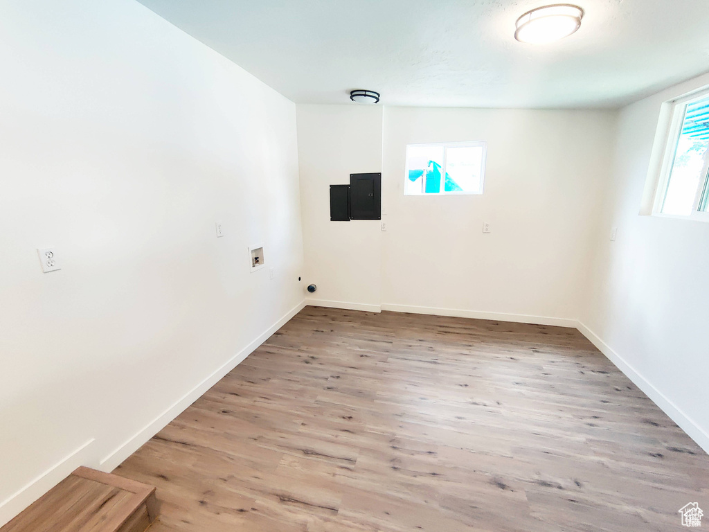 Empty room with a wealth of natural light and hardwood / wood-style flooring