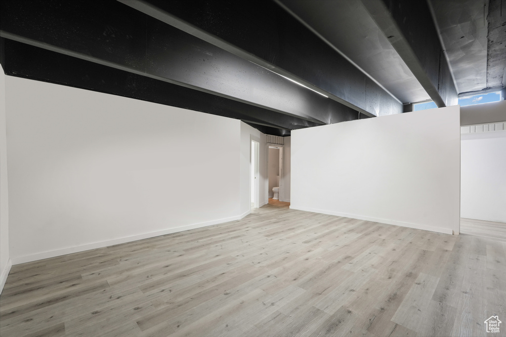 Basement with light hardwood / wood-style flooring