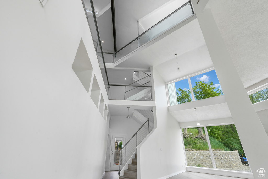 Staircase featuring a healthy amount of sunlight and a high ceiling