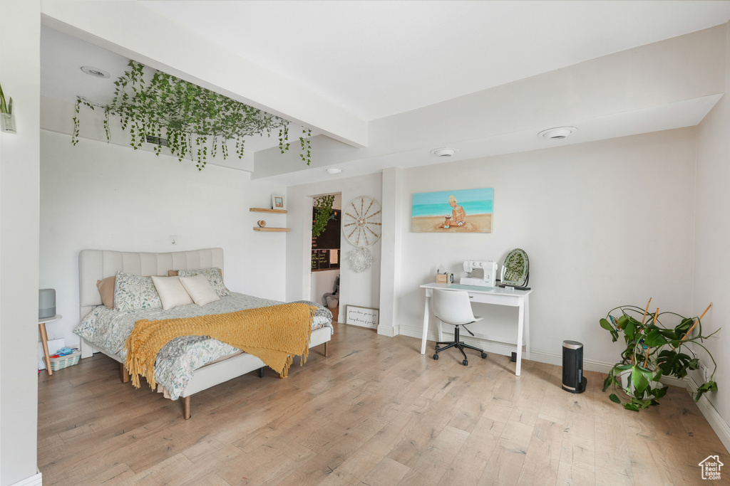 Bedroom featuring hardwood / wood-style floors and beamed ceiling