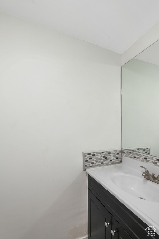 Bathroom featuring backsplash, vanity, and hardwood / wood-style flooring