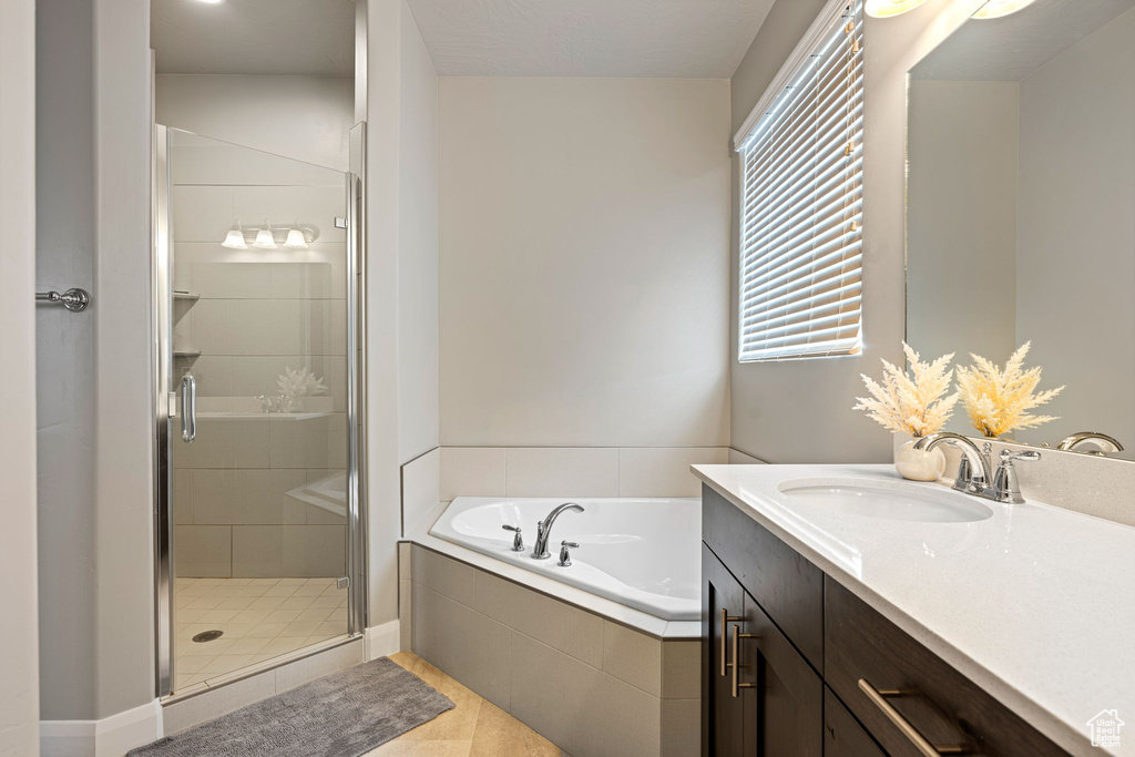 Bathroom featuring tile flooring, separate shower and tub, and large vanity