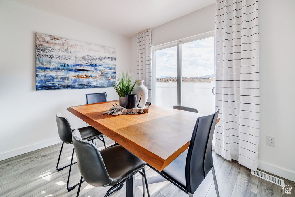 Dining area with hardwood / wood-style floors and a water view