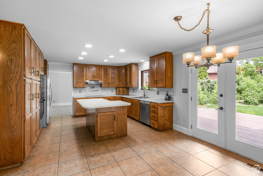 Kitchen with decorative light fixtures, a kitchen island, appliances with stainless steel finishes, light tile flooring, and an inviting chandelier