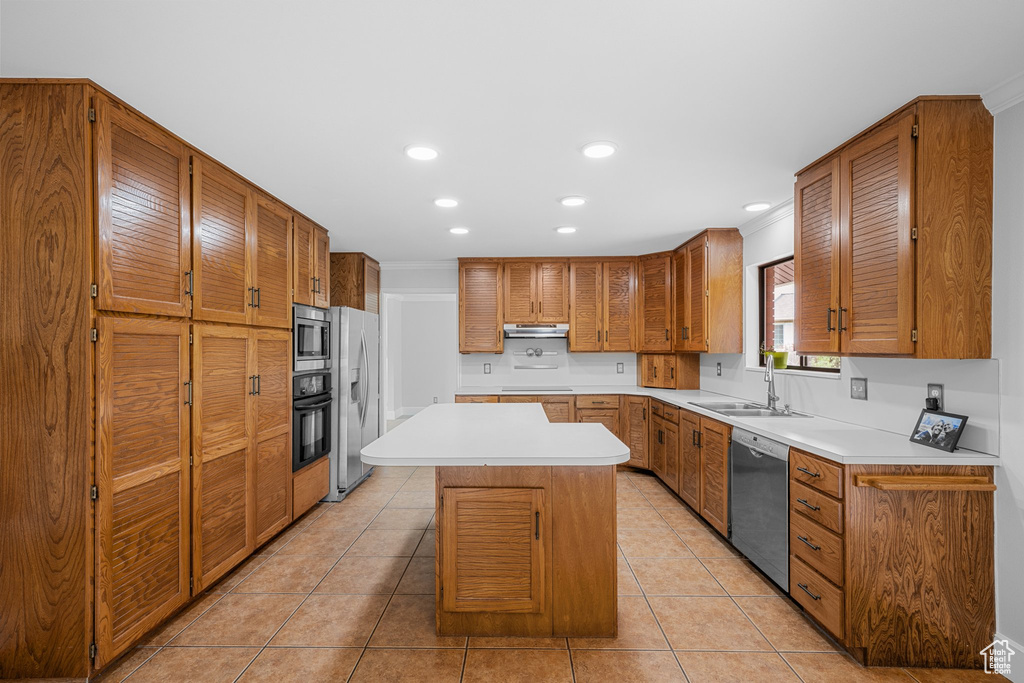 Kitchen featuring a kitchen island, stainless steel appliances, light tile floors, and sink
