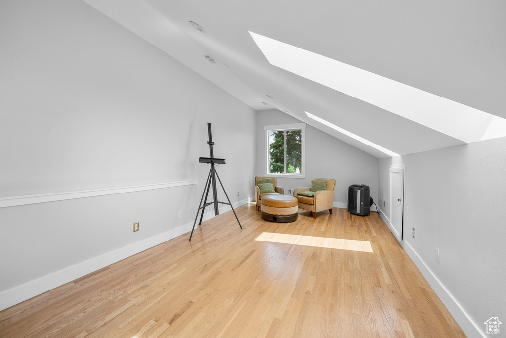 Bonus room featuring light hardwood / wood-style floors and lofted ceiling with skylight