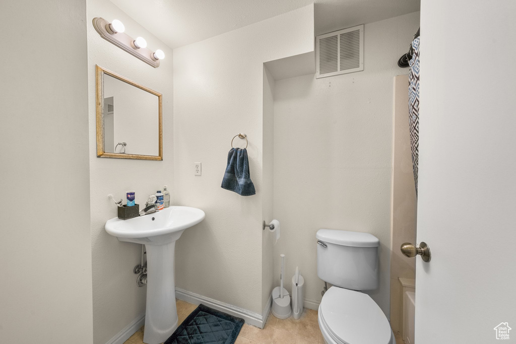 Full bathroom featuring shower / bath combo, toilet, tile flooring, and sink