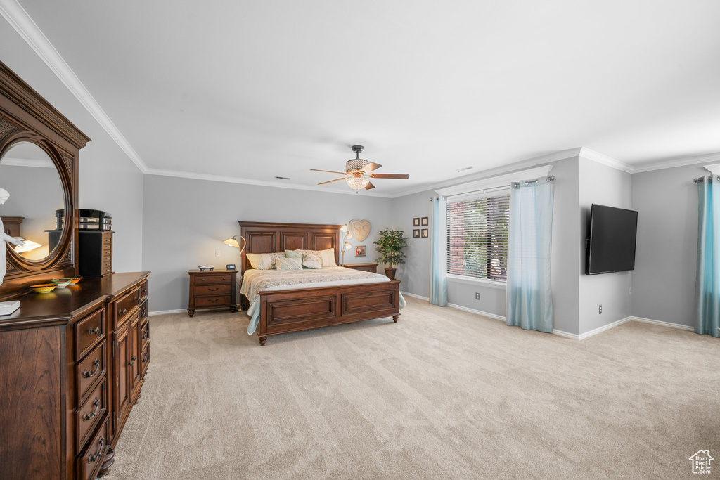 Bedroom with crown molding, light colored carpet, and ceiling fan