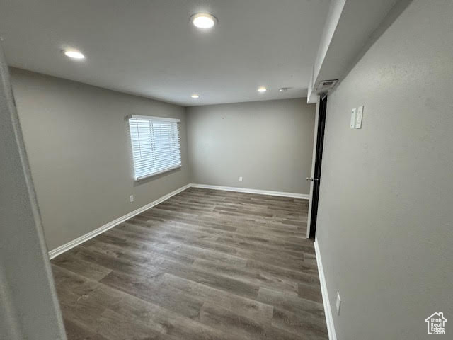 Spare room featuring dark wood-type flooring